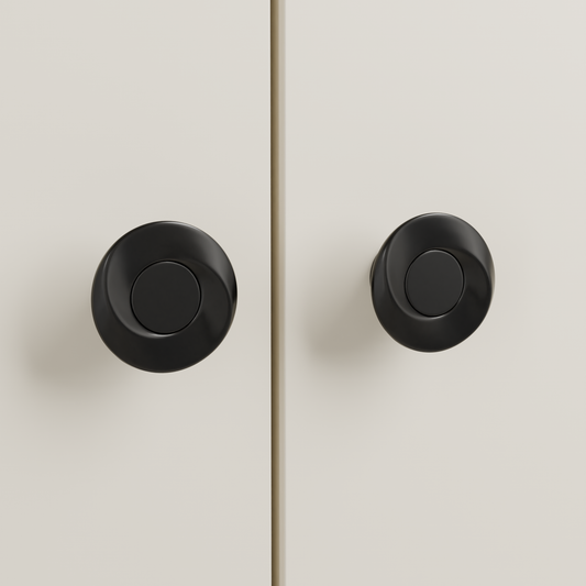 Callisto Knob in Polished Black + Matte Black installed on warm almond cabinetry - paired doors, square view