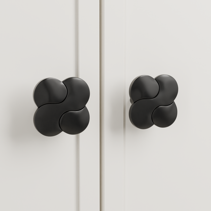 Saiph Knob in Polished Black + Matte Black installed on warm chalk cabinetry - paired doors, square view